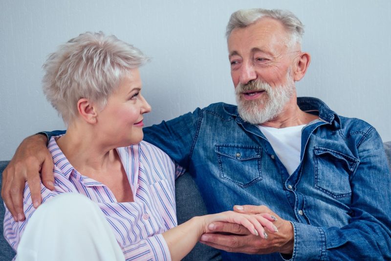 Mature good-looking well dressed couple sitting in sofa